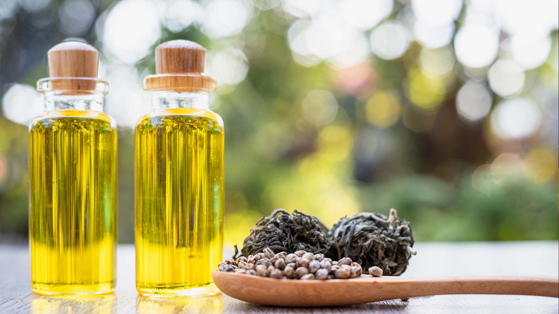 Bottles of CBD liquid and wooden spoon.