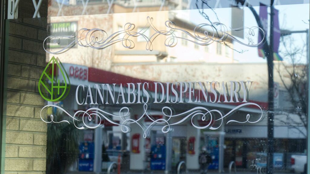 Window of storefront with Cannabis Dispensary sign.