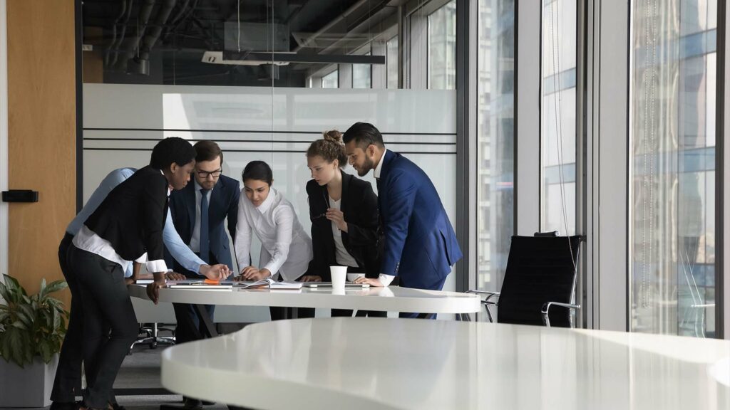 Group of professionals around a circular table looking at business plans