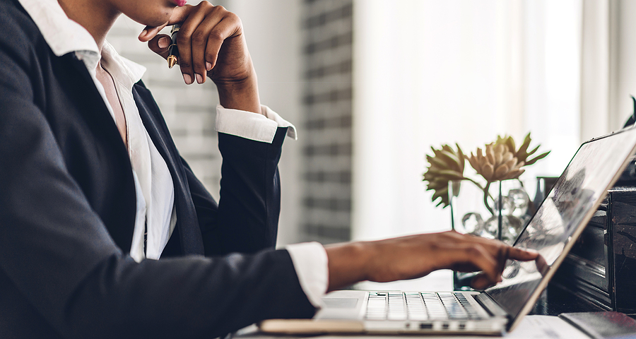 Closeup of businesswoman pointing a laptop screen, looking pensive