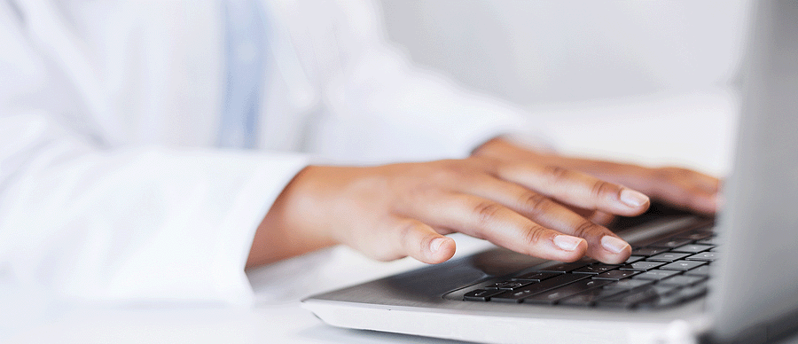 Closeup of Dr. hands typing of a computer