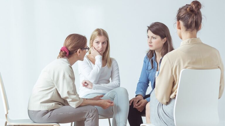 Women sitting in a circle talking to each other