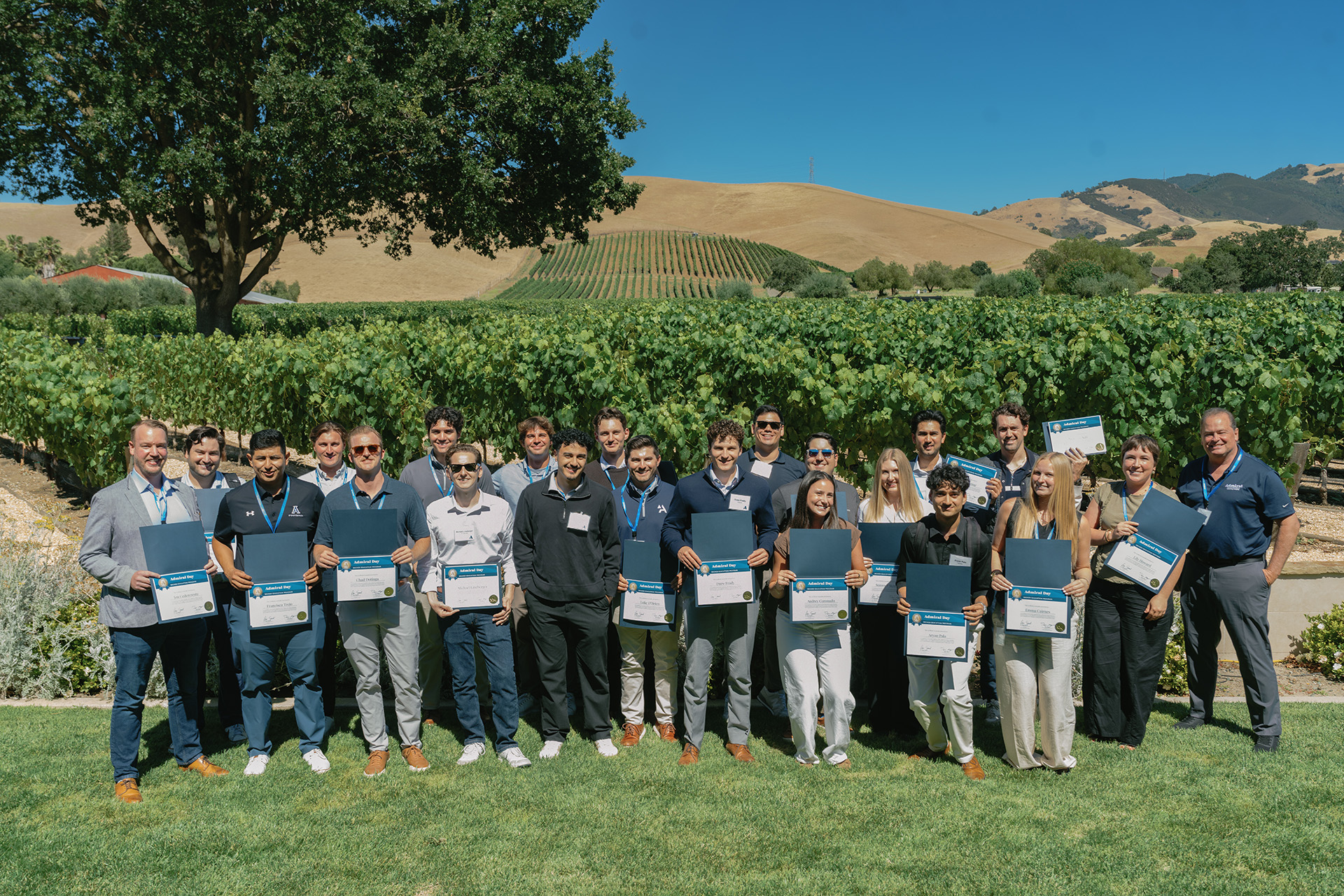 Graduates of Admiral Day San Francisco holding their certificates at a winery.